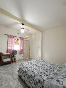um quarto com uma cama e uma ventoinha de tecto em Eco hostel 013 em São Vicente