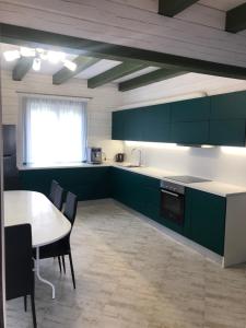 a kitchen with green cabinets and a table with chairs at Greenhouse in Voropayev