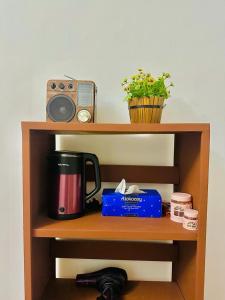 a shelf with a coffee maker and a radio at Sea Breeze Guest House in Negombo