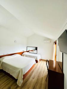Habitación de hotel con 2 camas y TV en Residencial Dona Teresa, en Maia