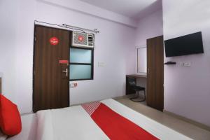 a bedroom with a bed and a door with a television at Flagship Noida Villa in Indirapuram