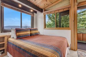 a bedroom with a bed and two windows at Laurelwood Condominiums 311 in Snowmass Village
