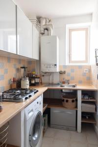 a kitchen with a sink and a washing machine at Nice cocoon with garden near the Bois de Vincennes in Saint-Maurice
