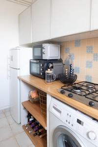a kitchen with a washer and a stove top oven at Nice cocoon with garden near the Bois de Vincennes in Saint-Maurice