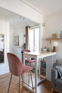 a living room with a desk and two pink chairs at Nice cocoon with garden near the Bois de Vincennes in Saint-Maurice