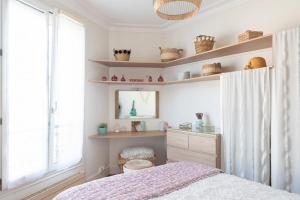 a bedroom with a bed and a window and shelves at Nice cocoon with garden near the Bois de Vincennes in Saint-Maurice