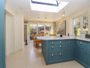 a kitchen with a blue island with a white counter top at Cherry Garden Cottage in Cranbrook