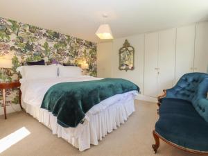 een slaapkamer met een groot bed en een stoel bij Cherry Garden Cottage in Cranbrook