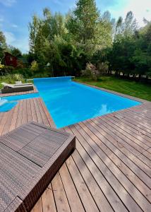 a swimming pool on a deck with a wooden deck at Leśny Raj in Świętajno