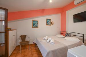 1 dormitorio con 2 camas y 1 silla en Studio rene 4, en Tinos