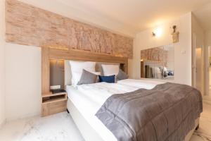 ein Schlafzimmer mit einem großen Bett und einer Holzwand in der Unterkunft Hotel & Restaurant Sparta in Oldenburg