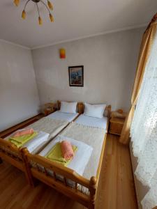 een slaapkamer met 2 bedden en handdoeken bij Къща за гости Иглика in Trigrad