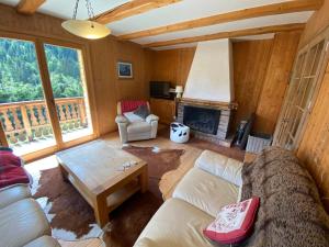 a living room with a couch and a fireplace at Chalet 5 Chambres à Châtel avec Multi Pass Été et 4 Salles de Bain – Confort et Charme Alpins - FR-1-693-1 in Châtel