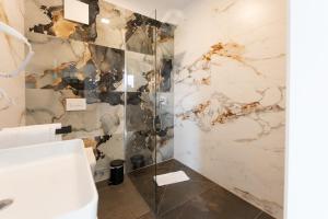 a bathroom with a sink and a marble wall at Hotel & Restaurant Sparta in Oldenburg