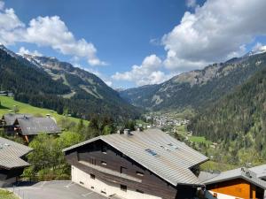 widok na dolinę z domem i góry w obiekcie Appartement cosy proche centre et pistes, balcon, parking - FR-1-693-43 w mieście Châtel