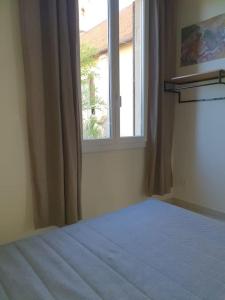 1 dormitorio con cama y ventana en Haut de maison 5 min de la plage, en Vallauris