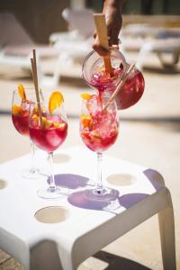 غوادالبين سويتس في مربلة: ثلاثة أكواب نبيذ مع الفاكهة على الطاولة