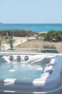 a hot tub with a view of the ocean at Sea Lilies Suites in Plaka