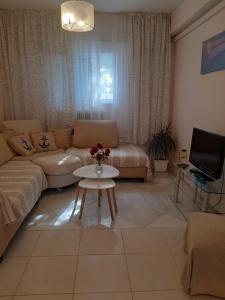ein Wohnzimmer mit einem Sofa und einem Tisch in der Unterkunft Cozy flat in Nea Makri in Nea Makri