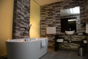 ein Bad mit einer Badewanne und einem Spiegel in der Unterkunft Amaryllis Hotel Blantyre in Blantyre