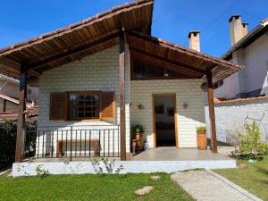 a small house with a wooden roof at Chalé Château do Luí in Monte Verde