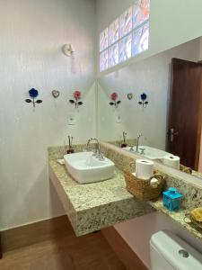 ein Badezimmer mit zwei Waschbecken und einem WC in der Unterkunft Chalé Château do Luí in Monte Verde