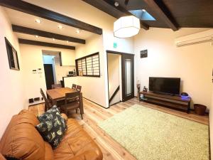 a living room with a couch and a table and a television at WeeklyHouse Biwako Otsu - Vacation STAY 62243v in Otsu