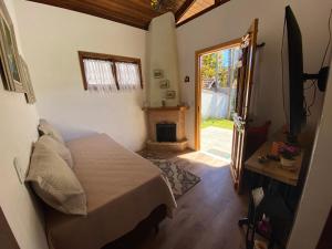 ein Schlafzimmer mit einem Bett und einer Tür zum Hof in der Unterkunft Chalé Château do Luí in Monte Verde