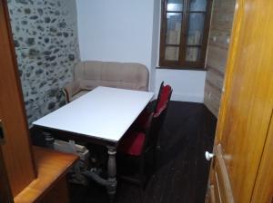 una mesa y sillas en una habitación con una mesa blanca y una ventana en Chambre à petit budget pour personne simple, en Saint-Laurent-de-Neste