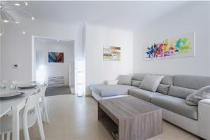 ein weißes Wohnzimmer mit einem Sofa und einem Tisch in der Unterkunft LUX Seaview & Pool-Hosted by Sweetstay in Mellieħa