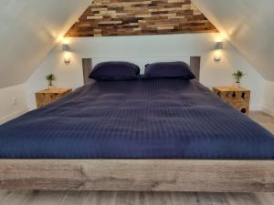 a large bed with blue comforter in a room at La vie Est Belle Vlissingen in Vlissingen
