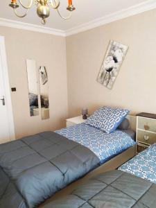 a bedroom with two beds and two pictures on the wall at Couleur Framboise in Longwy