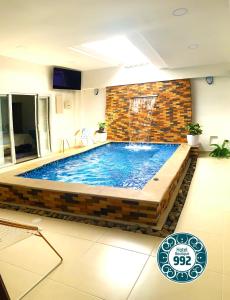 - une piscine dans une chambre dotée d'un mur en briques dans l'établissement Casa 9-92 Hotel Boutique, à Guaduas