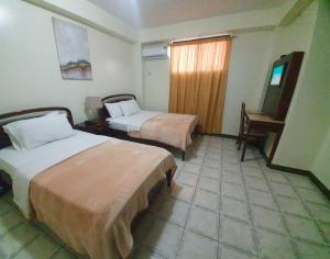 una habitación de hotel con 2 camas y un piano en Hotel Cisne II en Santa Elena
