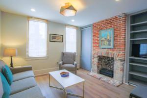 a living room with a couch and a fireplace at Gertie Downtown in Charleston