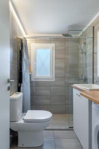 a bathroom with a toilet and a sink and a window at Faraklata Cottages in Faraklata