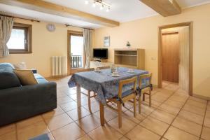 un soggiorno con un tavolo e un divano di Bait dal Cucù App Plascianet a Livigno Altre 18 foto