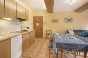 una cucina e una sala da pranzo con tavolo e sedie di Bait dal Cucù App Plascianet a Livigno