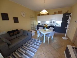 ein Wohnzimmer mit Sofa und Tisch und eine Küche in der Unterkunft Flat Le Rose in Paratico