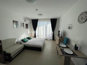 a bedroom with a bed and a couch and a clock at Admiral Plaza in Sunny Beach +22 photos