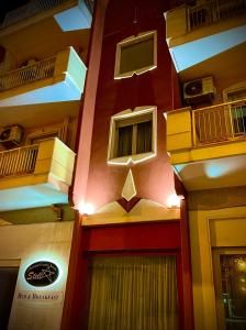 Un edificio con una pared roja con ventanas y una puerta. en STELLA CHARMING & LUXURY ROOMS, en Conversano
