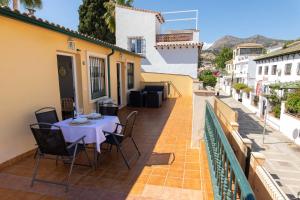 patio con mesa y sillas en el balcón en Pedregalejo Madueño 10, en Málaga