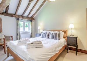 a bedroom with a large white bed with two towels on it at Brand Barn Sutton in Sutton