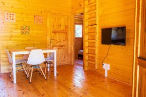 ein Esszimmer mit einem Tisch und Stühlen sowie einem TV in der Unterkunft Chalet Gayar in La Plaine des Cafres