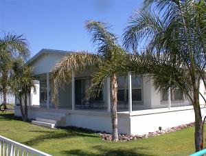 a house with palm trees in front of it at Waterfront Colorado River Home With Private Dock! in Needles