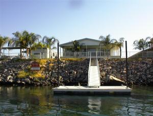 a dock in front of a house on a body of water at Waterfront Colorado River Home With Private Dock! in Needles