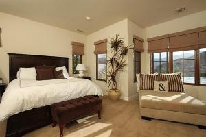 a bedroom with a large bed and a chair at Stunning Rancho Mirage Hilltop Compound in Rancho Mirage
