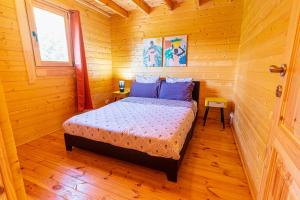 1 dormitorio con 1 cama en una habitación de madera en Chalet Gayar, en La Plaine des Cafres