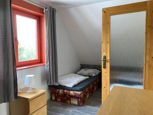 a small room with a bed and a window at Chata Severka in Dolný Kubín