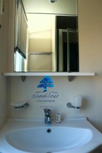 a bathroom sink with a mirror and a white sink at Mobilhome Côté mer - 3 Chambres - Climatisé - TV in Sigean